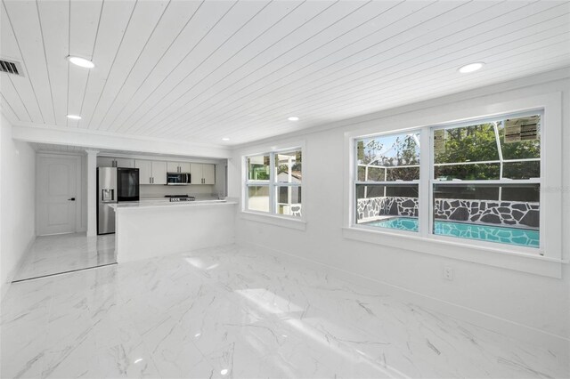 unfurnished living room with wood ceiling and crown molding