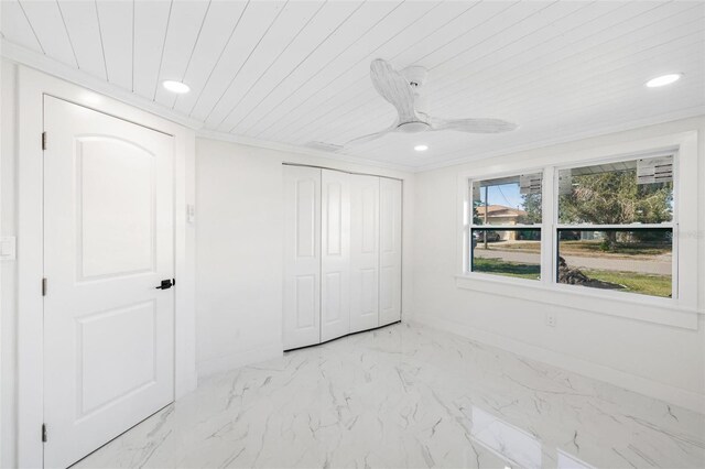 unfurnished bedroom with wooden ceiling, a closet, ceiling fan, and ornamental molding