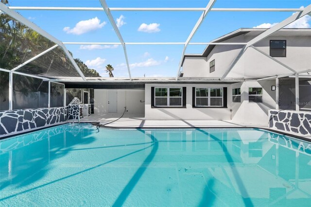 view of swimming pool featuring a lanai and a patio area