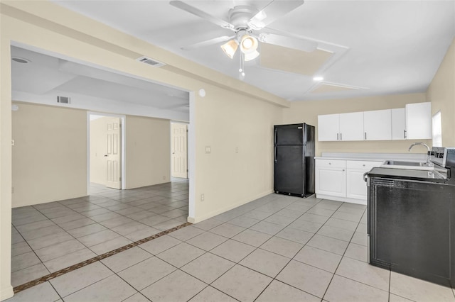 kitchen with black refrigerator, white cabinetry, ceiling fan, and light tile patterned flooring