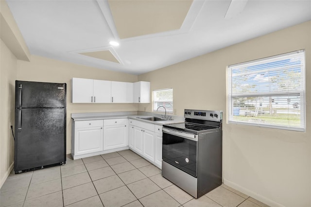 kitchen with black fridge, sink, light tile patterned floors, white cabinets, and stainless steel electric range oven