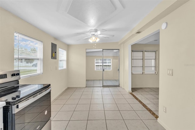 kitchen featuring stainless steel electric range, light tile patterned flooring, electric panel, and ceiling fan