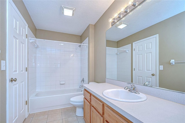 full bathroom featuring tile patterned floors, vanity, a textured ceiling, toilet, and tiled shower / bath