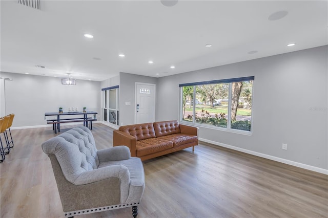 living room featuring light hardwood / wood-style floors and an inviting chandelier