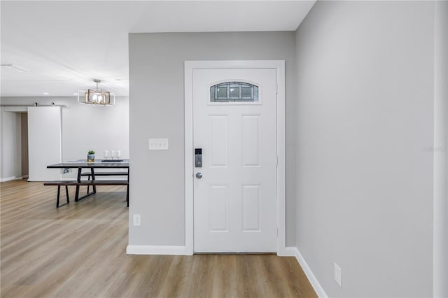 entrance foyer with a barn door and light hardwood / wood-style flooring