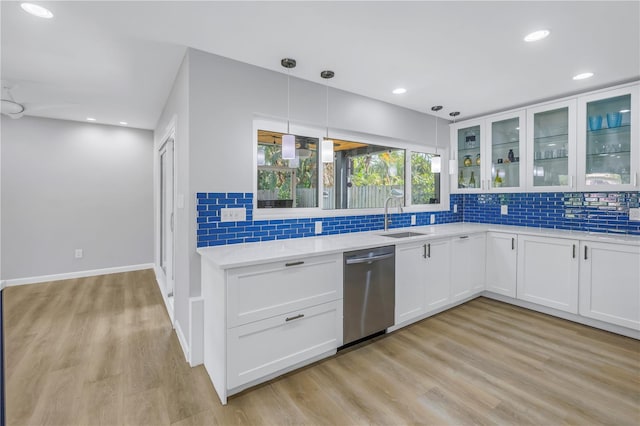 kitchen featuring light stone countertops, dishwasher, sink, pendant lighting, and white cabinets