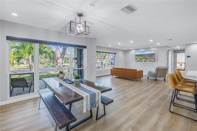 dining space with light wood-type flooring and a chandelier