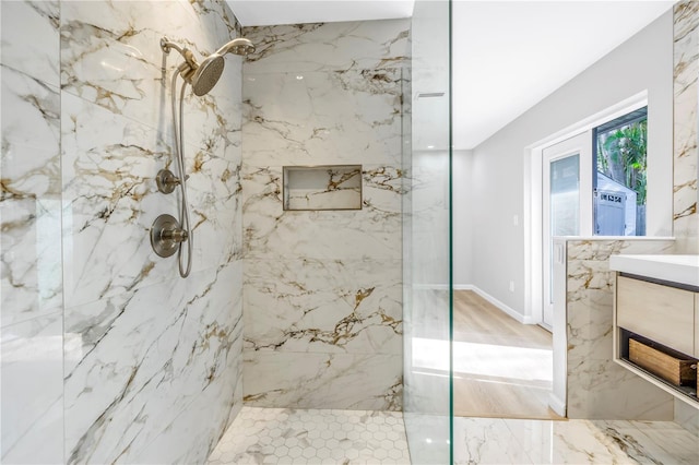 bathroom featuring a tile shower and vanity