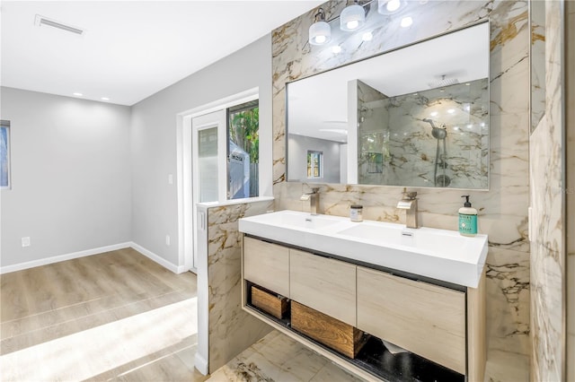 bathroom featuring a tile shower, vanity, and hardwood / wood-style flooring