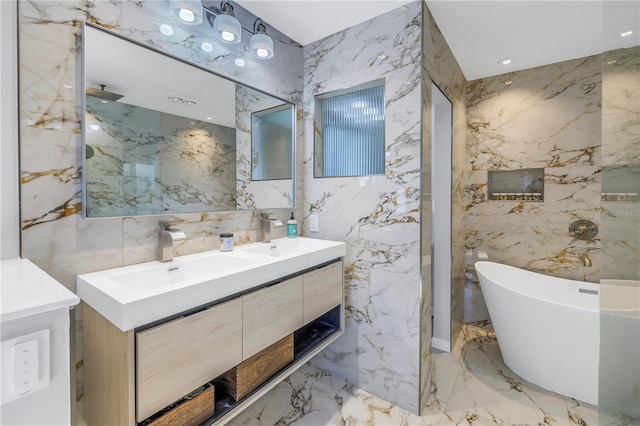 bathroom featuring vanity, a bath, and tile walls