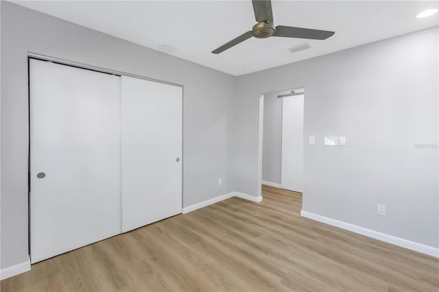 unfurnished bedroom with ceiling fan, a closet, and light hardwood / wood-style flooring