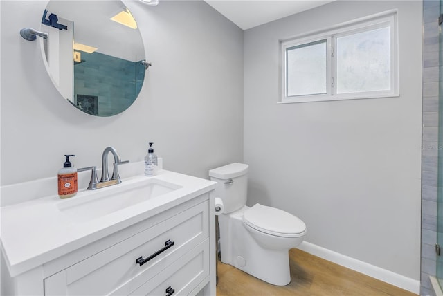 bathroom with walk in shower, toilet, vanity, and hardwood / wood-style flooring