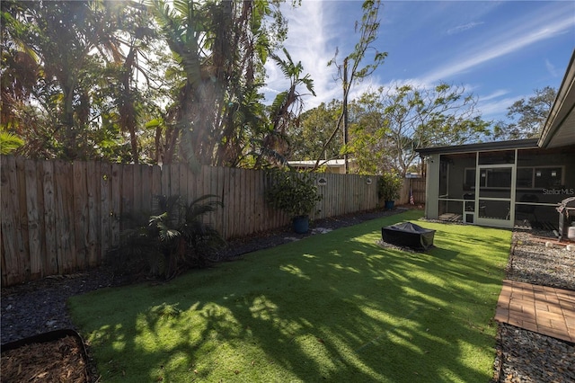 view of yard with an outdoor fire pit and a sunroom