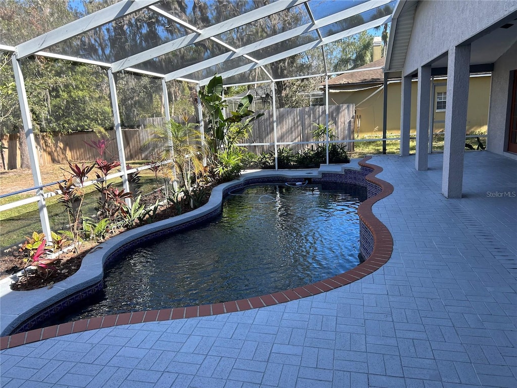 view of pool with a patio and glass enclosure