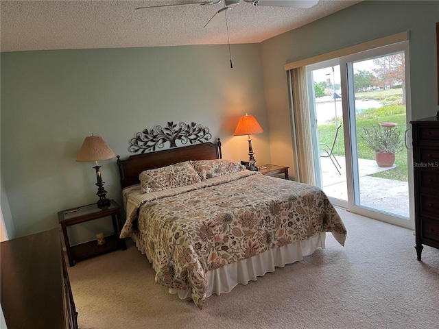 carpeted bedroom with ceiling fan, access to exterior, and a textured ceiling