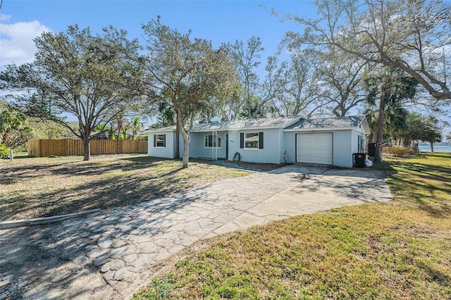 ranch-style home featuring a garage and a front yard