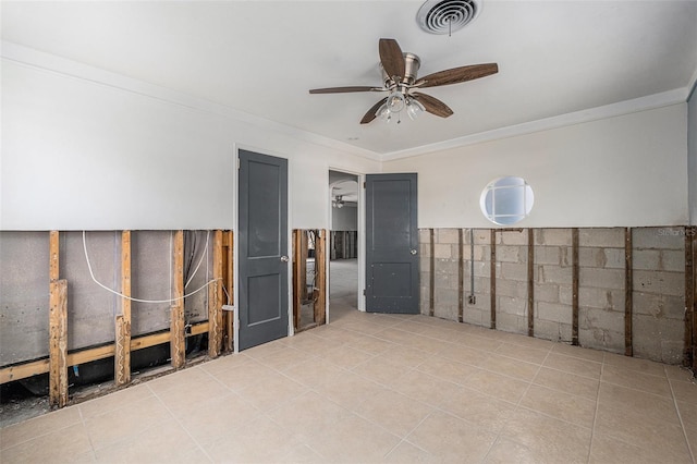 tiled empty room featuring ceiling fan and crown molding