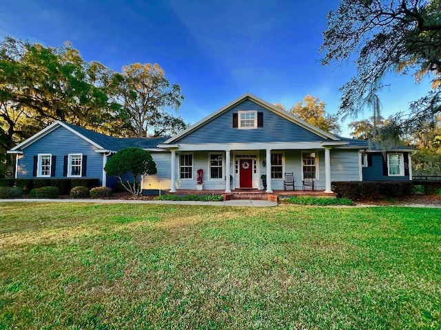 view of front of home with covered porch and a front lawn