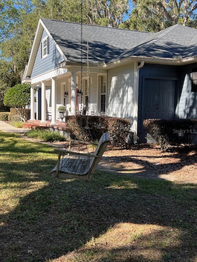 view of side of home with a lawn and a porch