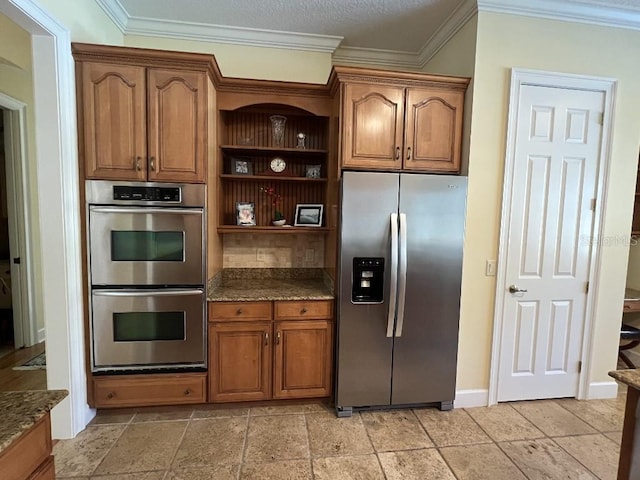 kitchen with crown molding, stainless steel appliances, and dark stone counters