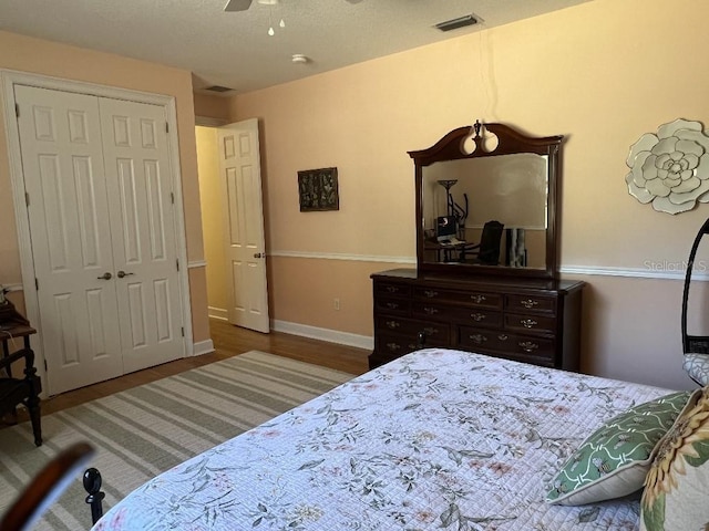 bedroom with ceiling fan, dark hardwood / wood-style floors, and a closet