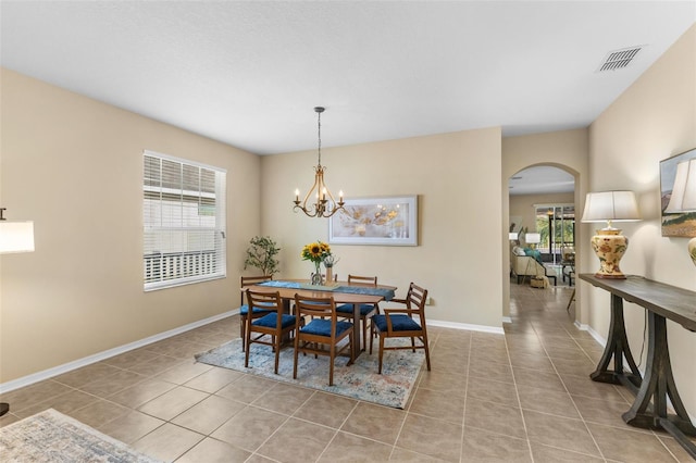 dining room featuring an inviting chandelier, a wealth of natural light, and light tile patterned flooring