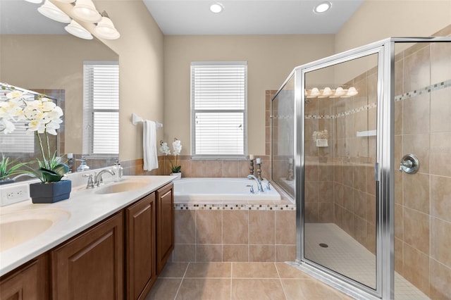 bathroom featuring plus walk in shower, vanity, and tile patterned floors