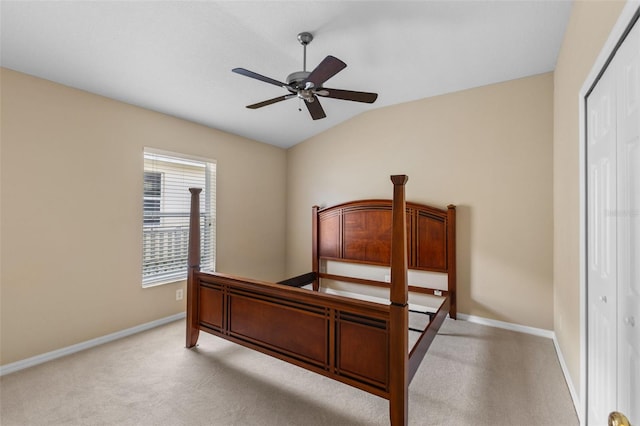 carpeted bedroom featuring ceiling fan, lofted ceiling, and a closet