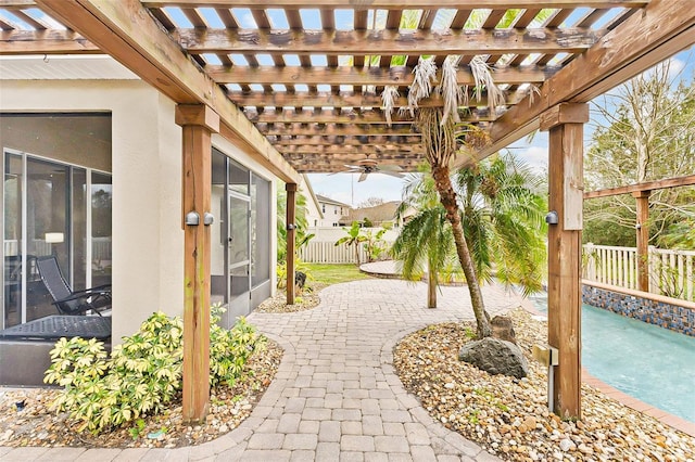 view of patio / terrace featuring a pergola, ceiling fan, and a sunroom