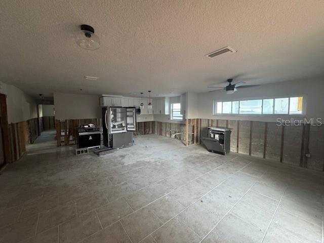 interior space featuring a textured ceiling, plenty of natural light, and ceiling fan