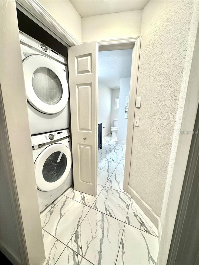 clothes washing area featuring stacked washer and dryer