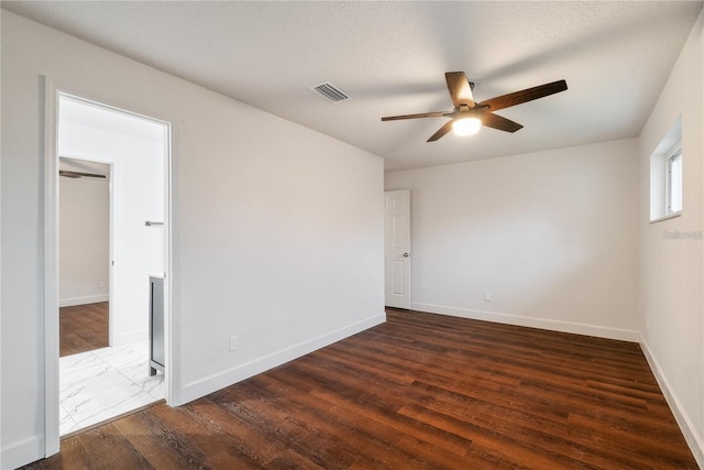 unfurnished room with a textured ceiling, ceiling fan, and dark hardwood / wood-style floors