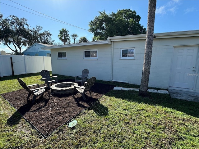 back of property featuring a yard and a fire pit