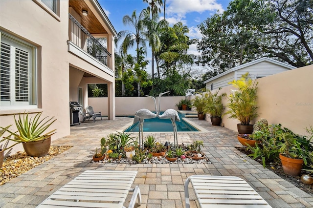 view of swimming pool featuring a grill and a patio