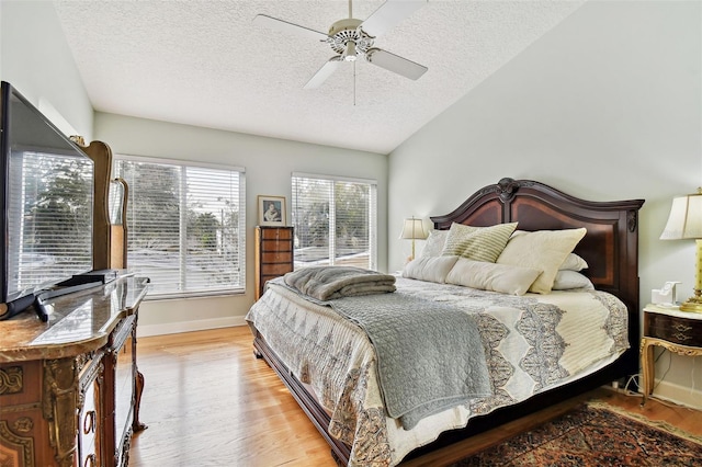 bedroom featuring vaulted ceiling, ceiling fan, a textured ceiling, and light hardwood / wood-style floors