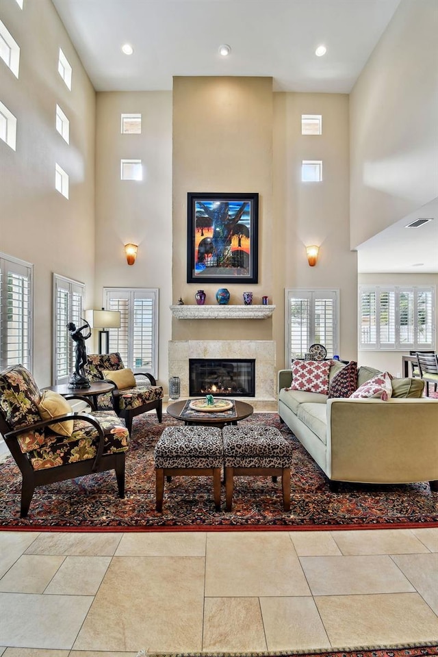 tiled living room with a high ceiling and a premium fireplace