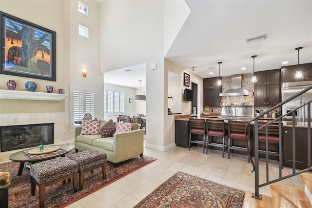 living room featuring light tile patterned floors, a high ceiling, and sink