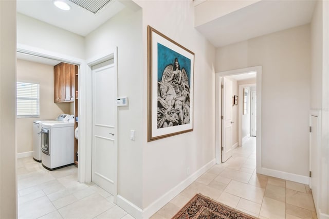 hallway featuring separate washer and dryer and light tile patterned floors