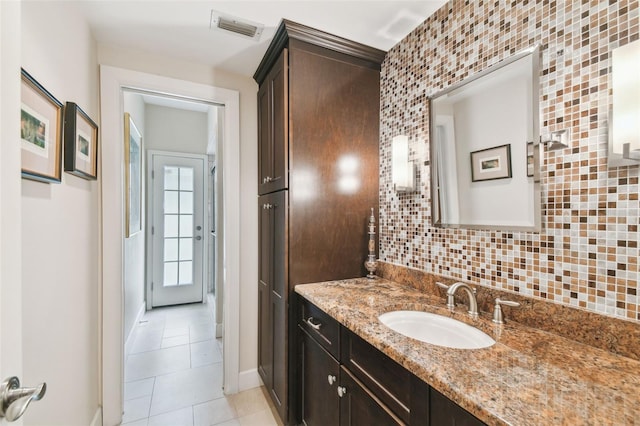 bathroom featuring tasteful backsplash, vanity, and tile patterned flooring