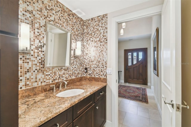 bathroom with decorative backsplash, vanity, and tile patterned flooring