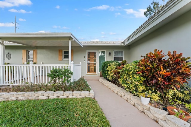 1985 Byram Dr, Clearwater, FL 33755 - view of exterior entry featuring stucco siding and a porch