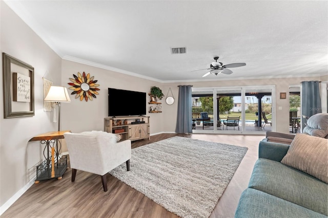 living room featuring hardwood / wood-style flooring, ceiling fan, and crown molding