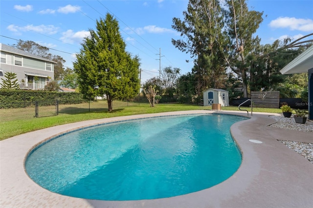 view of swimming pool with a storage shed and a lawn