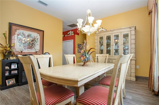 dining area featuring hardwood / wood-style floors and an inviting chandelier