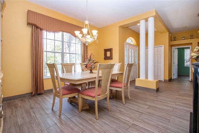 dining room with ornate columns and a chandelier