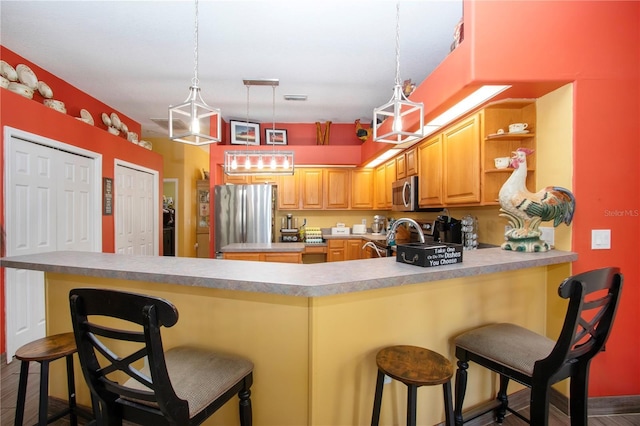 kitchen with kitchen peninsula, stainless steel appliances, and a breakfast bar area