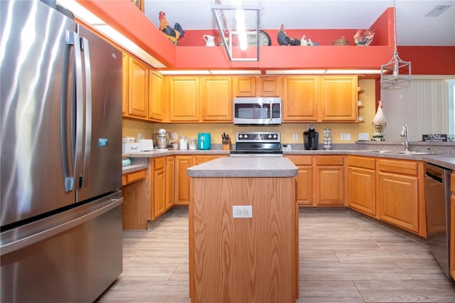 kitchen featuring light hardwood / wood-style floors, a center island, stainless steel appliances, and sink