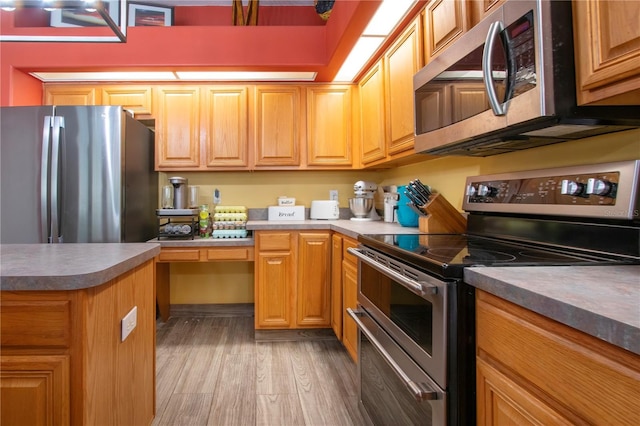 kitchen featuring hardwood / wood-style flooring and appliances with stainless steel finishes