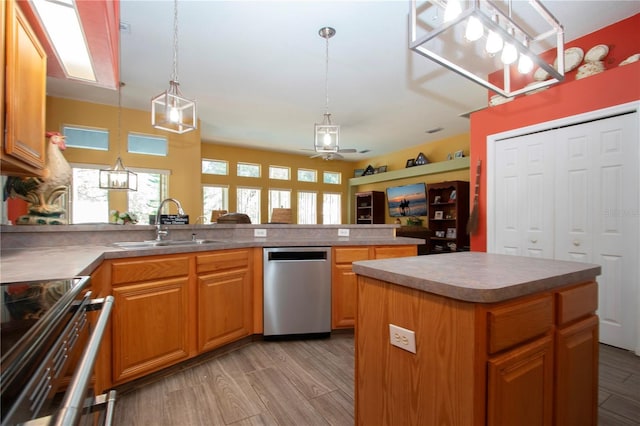 kitchen featuring appliances with stainless steel finishes, light hardwood / wood-style flooring, a kitchen island, and pendant lighting