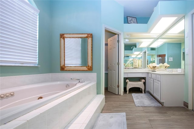 bathroom featuring vanity and a relaxing tiled tub